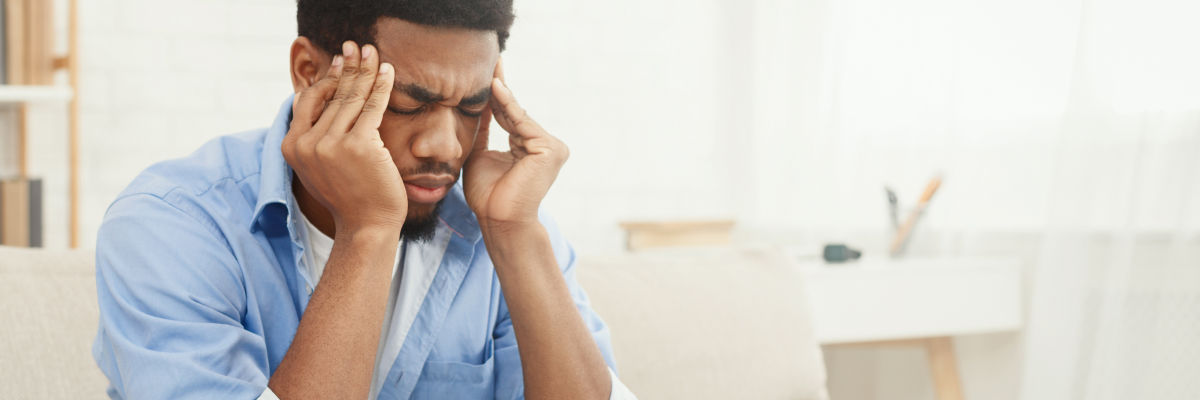 A man not wearing glasses with a headache